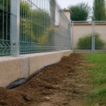 Clôturer un jardin pour chien : soubassement béton et clôture acier au ras du sol
